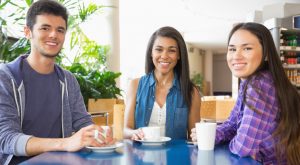 Young students smiling at camera in cafe at the university